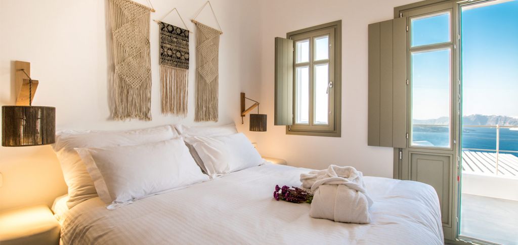 Cape 9 Deluxe Villa bedroom with open doors to the sea-view terrace